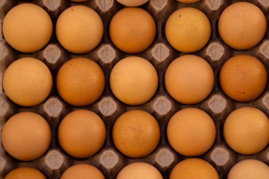 Top view of fresh brown eggs neatly placed in a cardboard egg tray.