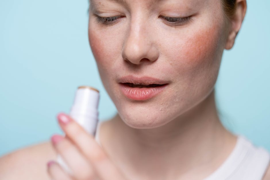 Close-up of a woman applying lip balm indoors. Ideal for skincare and beauty themes.