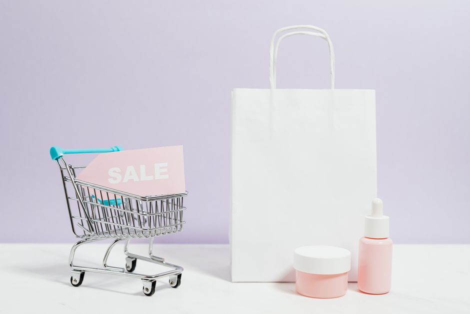 Aesthetic shopping scene with a white bag, cart, and cosmetics on sale.